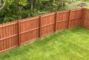 Wooden garden fence coated with medium oak colour paint UK