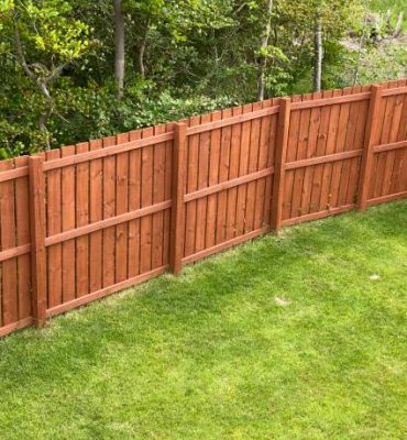 Wooden garden fence coated with medium oak colour paint UK