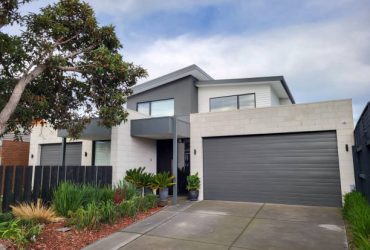 Melbourne, Australia: July 16, 2022: Modern semi-detahced house in the suburb of Chelsea with balcony, large double garage and landscaped garden to the front.