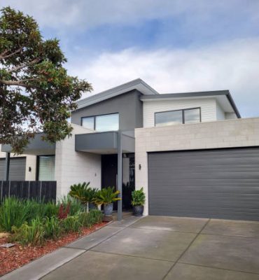 Melbourne, Australia: July 16, 2022: Modern semi-detahced house in the suburb of Chelsea with balcony, large double garage and landscaped garden to the front.